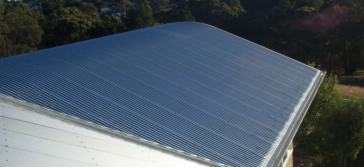 Gutter mesh gutter guard installed on a curved metal sheet roof.