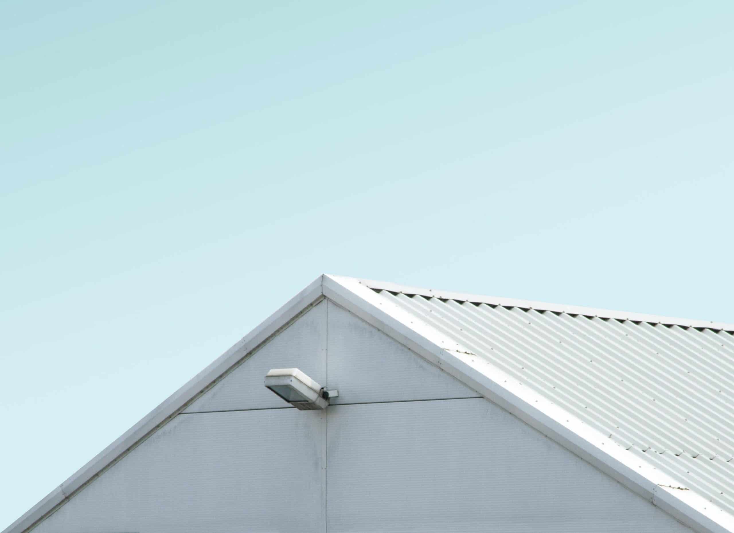 Side angle of white corrugated roof with light blue sky